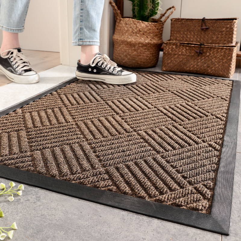 Person stepping onto a textured brown doormat with wicker baskets in the background.