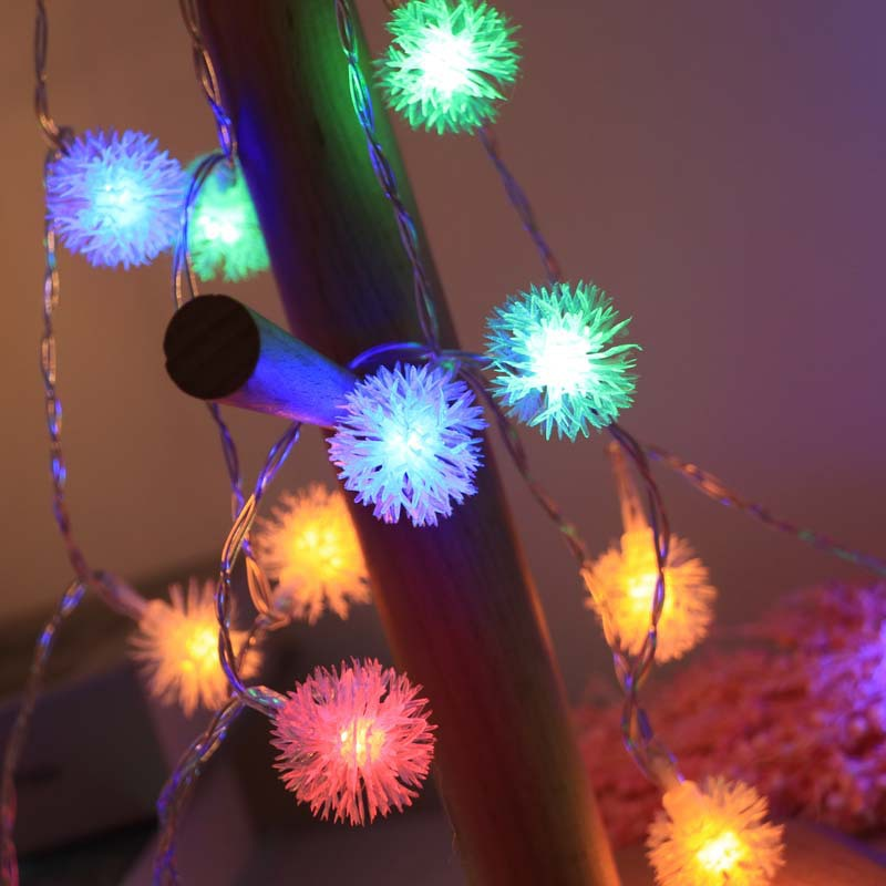 String lights with colorful, flower-shaped bulbs on a dark background