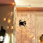 Halloween spider web decoration with lights hanging on a door frame.