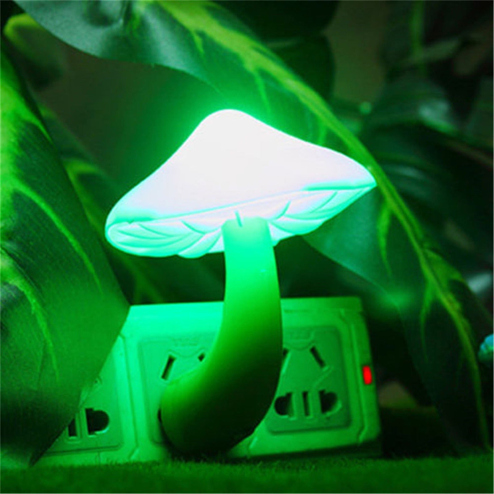 Mushroom-shaped night light emitting a green glow on a grassy background.