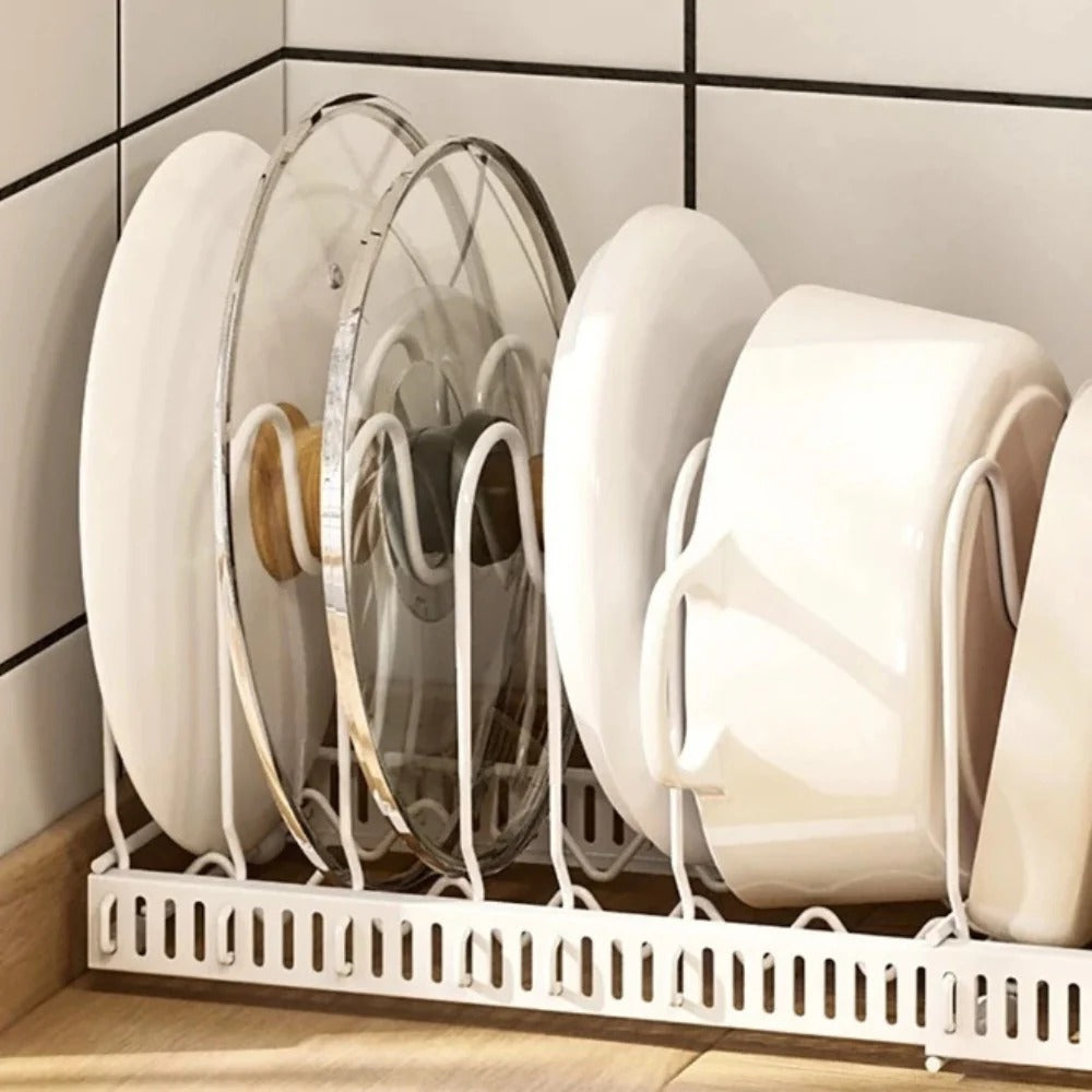 White dish rack with plates, bowls, and cups on a tiled kitchen wall.