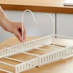White dish drying rack being adjusted on a wooden surface