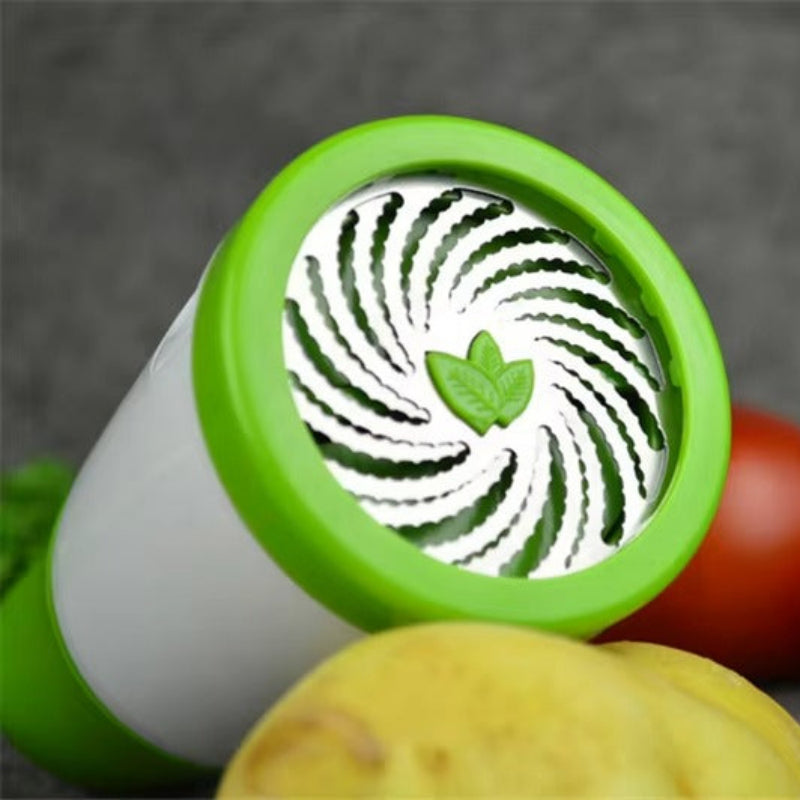 Vegetable peeler with green handle and white spiral design, surrounded by tomatoes and a potato on a gray background.