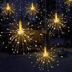 Decorative string lights resembling fireworks in a snowy outdoor setting.