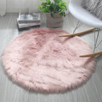 Round pink fluffy rug on a light wooden floor with a plant and books in the background.