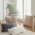 Furry cushions in various colors on a chair and bed in a bright room.