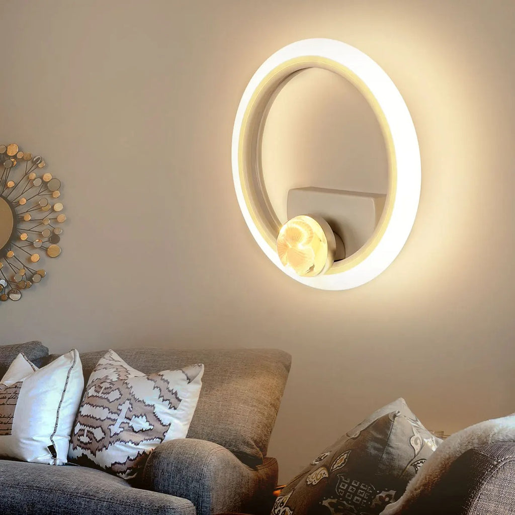 Decorative wall mirror with a light fixture in a living room setting.