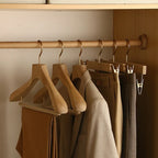 Clothing items on wooden hangers in a closet
