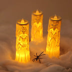 Three glowing LED candlelight figurines shaped like bride, groom, and skeleton wedding couple candles, arranged in white faux snow with a small black spider decoration in the foreground.