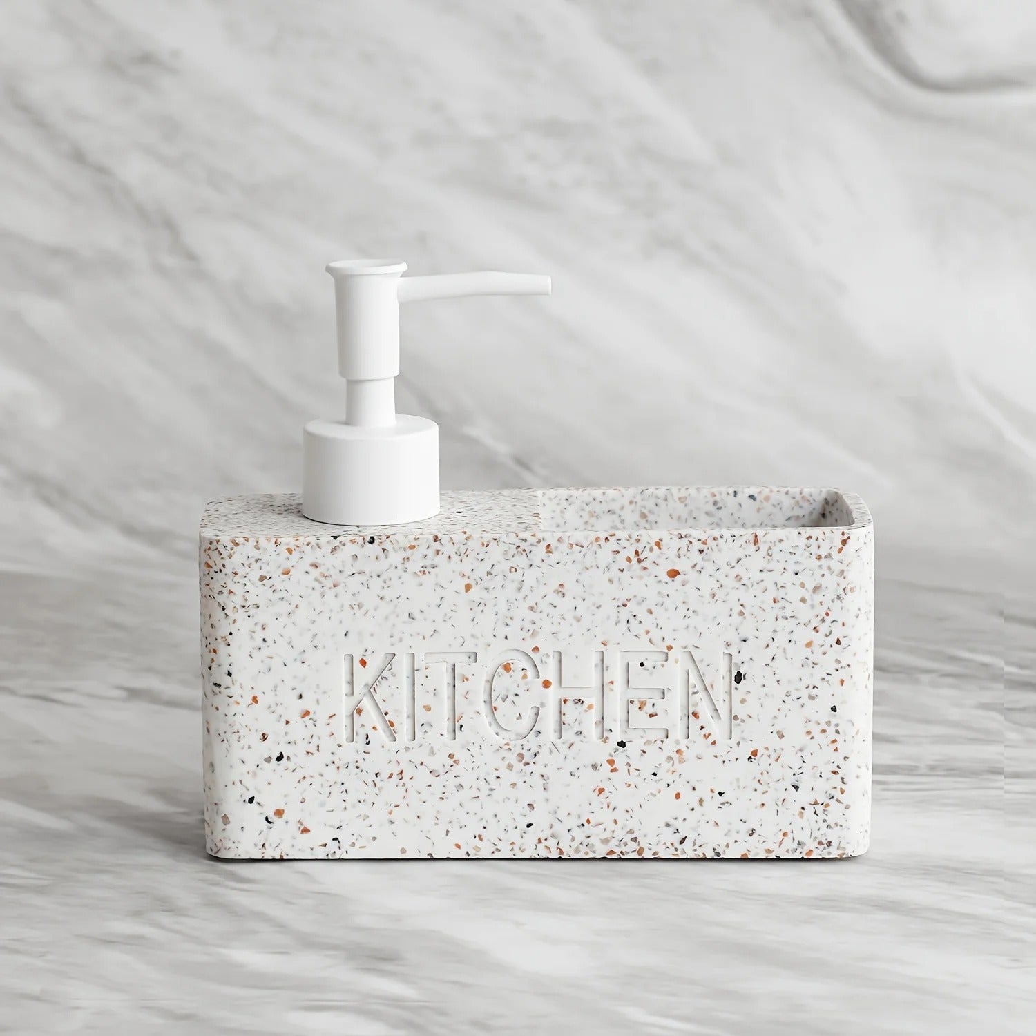 Concrete soap dispenser with 'KITCHEN' embossed on it against a marble background