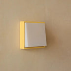Light switch with yellow frame on a beige wall