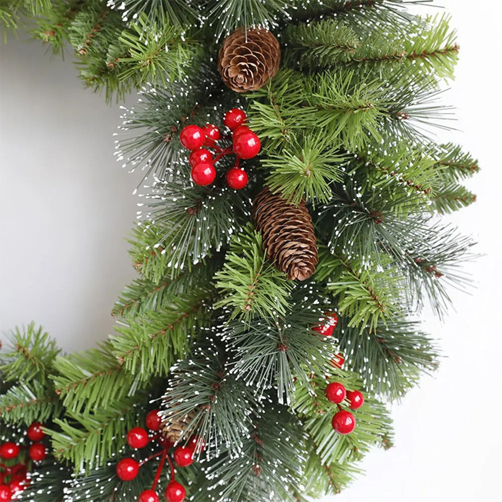 Christmas garland with green pine branches, red berries, and brown pine cones on a white background.