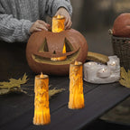 Halloween-themed candles and a carved pumpkin on a table with a blurred background