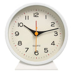 White clock with a beige face on a white background