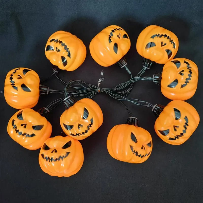 A set of 10 jack-o'-lantern Halloween string lights arranged in a circle on a black background. The lights are bright orange with black plastic wiring and carved faces.