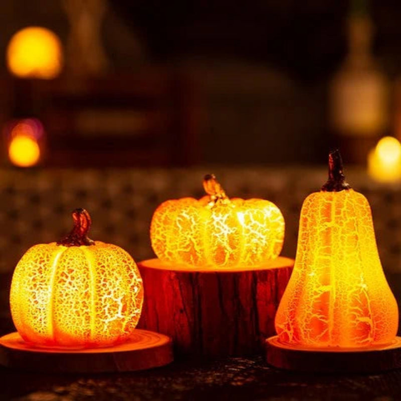 Three decorative pumpkins with a textured surface, glowing warmly against a blurred background.