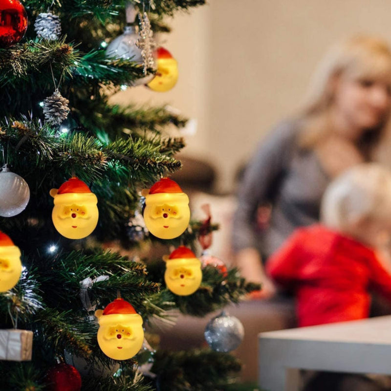 Decorative Christmas tree with festive ornaments, including a woman and child in the background.