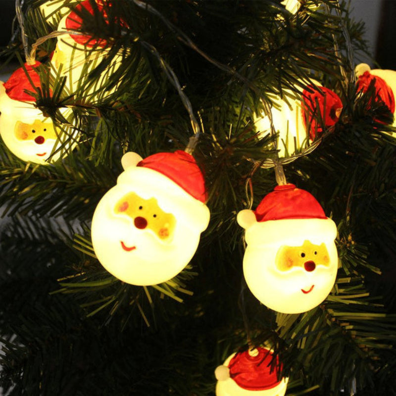 String lights shaped like Santa Claus heads on a Christmas tree.
