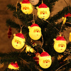 String of Santa Claus-shaped lights on a Christmas tree.