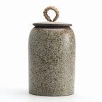 Ceramic jar with textured surface and ring handle on a white background
