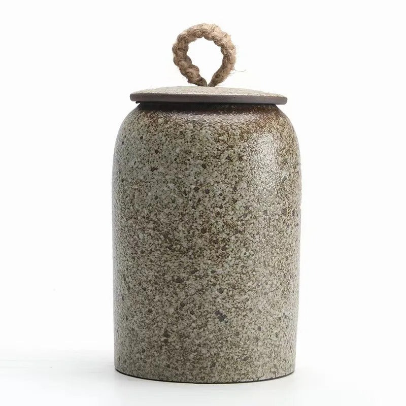 Ceramic jar with textured surface and ring handle on a white background