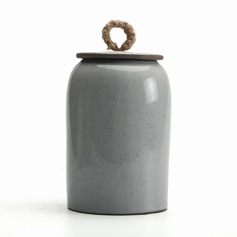 Gray ceramic jar with a wooden lid on a white background