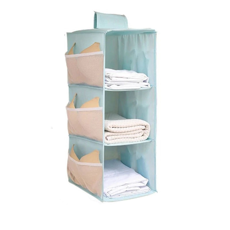 A light blue fabric hanging organizer with three open shelves and three mesh side pockets, shown with folded towels and bras inside. Black measurement lines and text indicate dimensions of 60cm height, 30cm width, and 22cm depth on a white background.