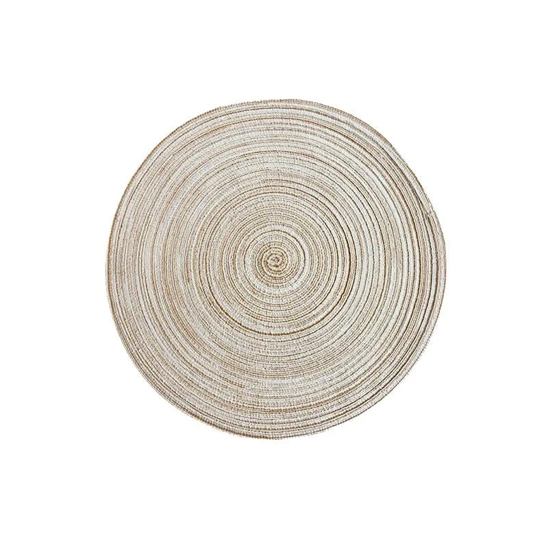 Round woven placemat with concentric circle pattern on a white background